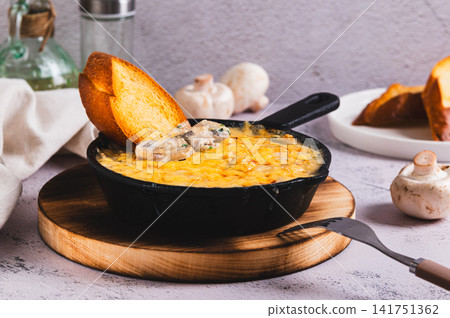 Delicious julienne with mushrooms and cheese in a frying pan on the table Delicious julienne with mushrooms and cheese in a frying pan on the table 141751362