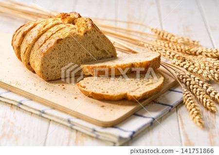 wheat bread with sourdough on white kitchen table, selective focus. wheat bread with sourdough on white kitchen table, selective focus. 141751866