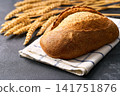 loaf of wheat bread with sourdough with ears of wheat on dark kitchen table, selective focus 141751876