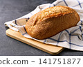 loaf of freshly artisan bread or traditional wheat rustic bread on dark kitchen table, selective focus. 141751877