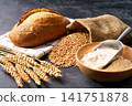 wheat bread with sourdough on dark kitchen table with flour and ears of wheat. 141751878
