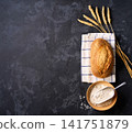 wheat bread with sourdough on dark kitchen table with flour and ears of wheat. 141751879
