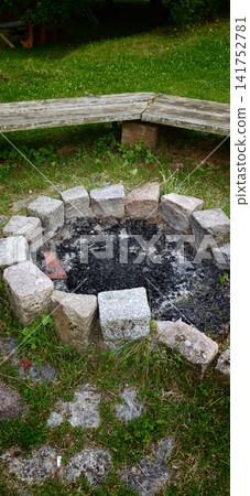 Campfire site with stones around and benches nearby in a grassy area Campfire site with stones around and benches nearby in a grassy area 141752781
