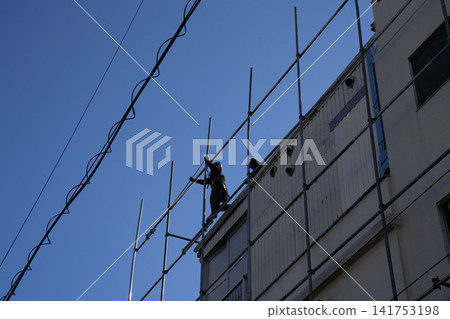 建築工地的景象:鷹架直插藍天,建築工人的身影,以及整體印象。 建築工地的景象:鷹架直插藍天,建築工人的身影,以及整體印象。 141753198