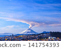 Cotopaxi volcano, active and emitting a column of gas and steam, seen at dawn from Quito, Ecuador. 141754393