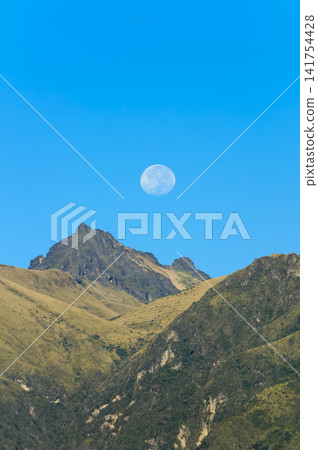 Full moon over majestic Rucu Pichincha under a clear blue sky Full moon over majestic Rucu Pichincha under a clear blue sky 141754428