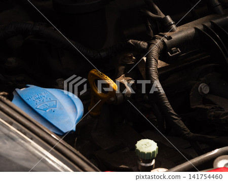 Engine oil dipstick and screenwash tank in car Engine oil dipstick and screenwash tank in car 141754460