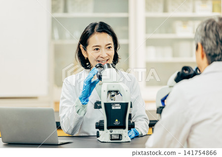 在實驗室中使用顯微鏡進行研究的研究人員 141754866