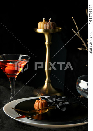 Halloween. Beautifully arranged table features Halloween-themed decorations and treats 141754943
