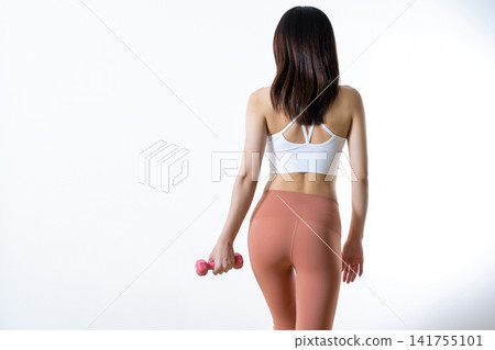一位身材苗條的女性背影,手持啞鈴;健身愛好者;減肥;節食。 一位身材苗條的女性背影,手持啞鈴;健身愛好者;減肥;節食。 141755101