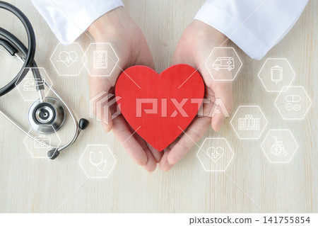 A composite image of a doctor's hand holding a heart object and medical icons. A composite image of a doctor's hand holding a heart object and medical icons. 141755854