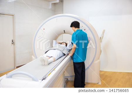 患者正在接受CT掃描,放射科醫師也在場。照片由東京電子大學電波學園教育基金會提供。 患者正在接受CT掃描,放射科醫師也在場。照片由東京電子大學電波學園教育基金會提供。 141756085