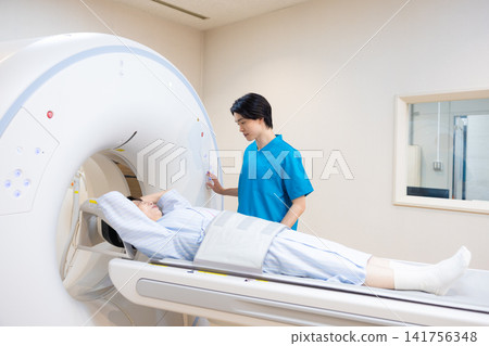 Patient undergoing a CT scan and radiologist. Photo courtesy of Denpa Gakuen Educational Foundation, Tokyo Electronics College. Patient undergoing a CT scan and radiologist. Photo courtesy of Denpa Gakuen Educational Foundation, Tokyo Electronics College. 141756348