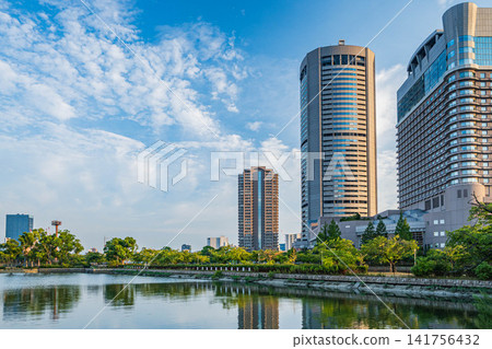 The OAP Tower, illuminated by the setting sun, in Osaka City. The OAP Tower, illuminated by the setting sun, in Osaka City. 141756432