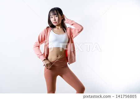 Image of a woman who lost weight by starting gym workouts and yoga; showing off her stomach while posing; a woman who works out. Image of a woman who lost weight by starting gym workouts and yoga; showing off her stomach while posing; a woman who works out. 141756805
