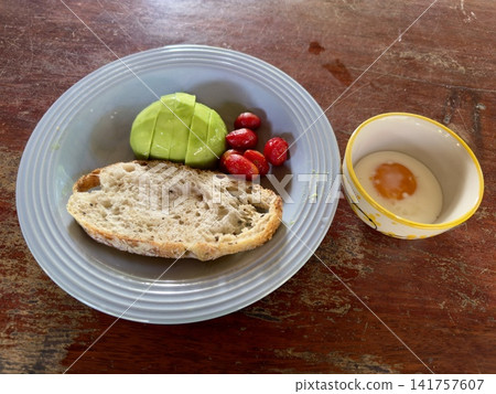 Close up view of delicious rustic sourdough toast with fresh avocado and cherry tomatoes on a wooden table Close up view of delicious rustic sourdough toast with fresh avocado and cherry tomatoes on a wooden table 141757607