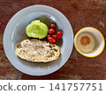Close up view of delicious rustic sourdough toast with fresh avocado, cherry tomatoes and egg on a wooden table 141757751