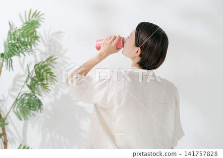 一名女子正在喝罐裝飲料 一名女子正在喝罐裝飲料 141757828