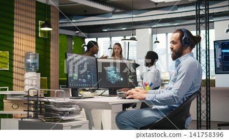 Software developer coding with AI language model assistance in office, listening music. Programmer wearing headphones integrating LLM assistant suggestions into code editor, camera A Software developer coding with AI language model assistance in office, listening music. Programmer wearing headphones integrating LLM assistant suggestions into code editor, camera A 141758396