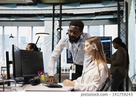Manager reviewing code snippets written by junior dev in modern workspace, adjusting configurations. Senior programmer and intern running diagnostic tools, monitoring API cloud services Manager reviewing code snippets written by junior dev in modern workspace, adjusting configurations. Senior programmer and intern running diagnostic tools, monitoring API cloud services 141759243