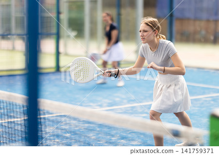 Young woman playing doubles padel tennis Young woman playing doubles padel tennis 141759371