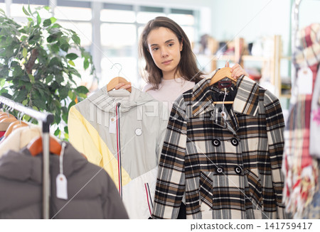 Young woman scans qr code of coat and jacket in store 141759417