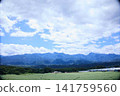 A vast plateau landscape with majestic mountain ranges and a clear blue sky. 141759560