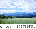 A vast plateau landscape with majestic mountain ranges and a clear blue sky. 141759561