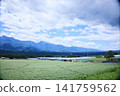 A vast plateau landscape with majestic mountain ranges and a clear blue sky. 141759562