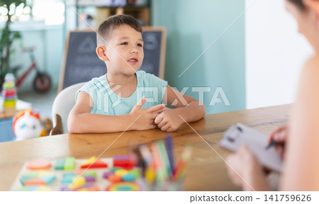 Little boy talking to child psychologist during survey Little boy talking to child psychologist during survey 141759626