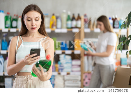 Woman scans dish detergent on her phone Woman scans dish detergent on her phone 141759678