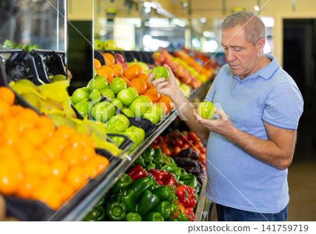 Elderly man purchaser buying fresh apples in grocery store Elderly man purchaser buying fresh apples in grocery store 141759719