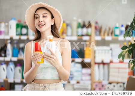 Woman choosing tanning products and sunscreen in the supermarket Woman choosing tanning products and sunscreen in the supermarket 141759729