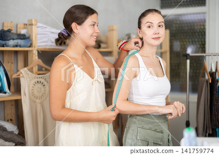 Woman measures female client Woman measures female client 141759774