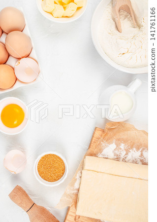 Croissant ingredients and puff pastry dough on white background, top view baking preparation concept Croissant ingredients and puff pastry dough on white background, top view baking preparation concept 141761166