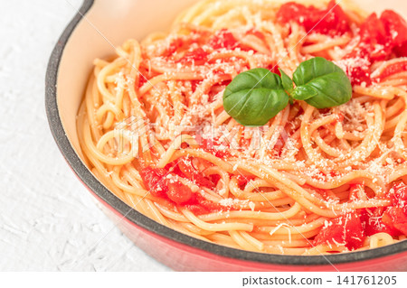 Spaghetti with tomato sauce and parmesan cheese garnished with basil in pan closeup 141761205