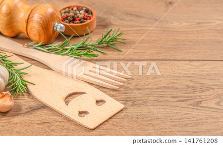 Rustic kitchen utensils with rosemary, garlic and spices on wooden table background with copy space Rustic kitchen utensils with rosemary, garlic and spices on wooden table background with copy space 141761208