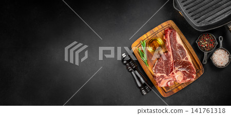 Raw porterhouse steak with grill pan and seasonings on dark background Raw porterhouse steak with grill pan and seasonings on dark background 141761318