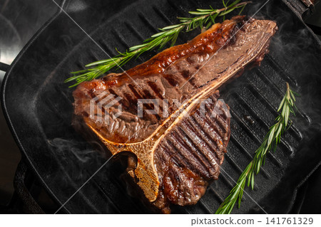 Grilled porterhouse steak with rosemary and smoke on cast iron grill pan Grilled porterhouse steak with rosemary and smoke on cast iron grill pan 141761329