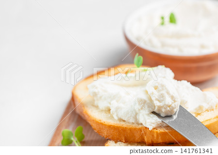 Cream cheese spread on toasted bread with knife Cream cheese spread on toasted bread with knife 141761341
