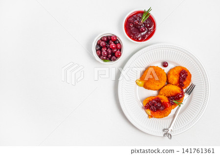 Traditional breaded cheese croquettes with cranberry sauce on white plate and copy space Traditional breaded cheese croquettes with cranberry sauce on white plate and copy space 141761361