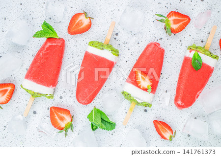 Strawberry kiwi yogurt popsicles with ice cubes on light background Strawberry kiwi yogurt popsicles with ice cubes on light background 141761373