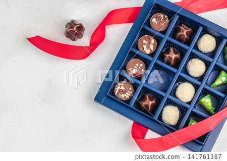 Assorted chocolates in gift box with red ribbon Assorted chocolates in gift box with red ribbon 141761387