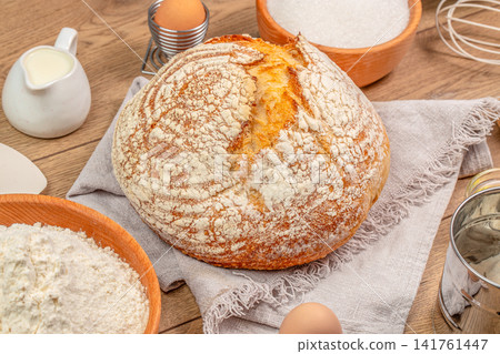 Artisan sourdough bread with baking ingredients on wooden table Artisan sourdough bread with baking ingredients on wooden table 141761447