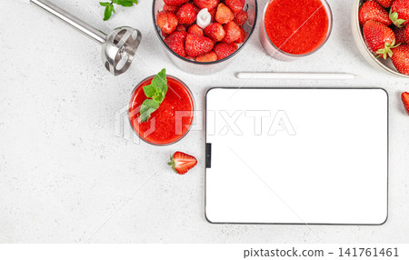 Strawberry smoothie preparation with tablet mockup and fresh ingredients Strawberry smoothie preparation with tablet mockup and fresh ingredients 141761461
