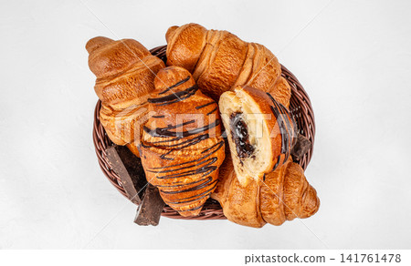 Chocolate croissants in wicker basket top view Chocolate croissants in wicker basket top view 141761478