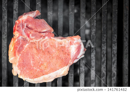 Raw pork chop on barbecue grill Raw pork chop on barbecue grill 141761482