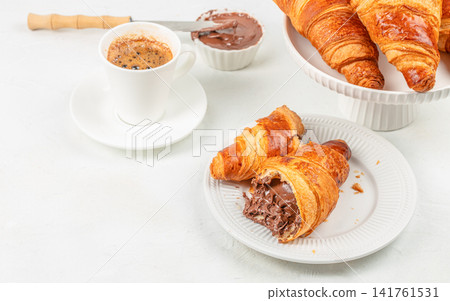 Chocolate filled croissants with espresso coffee breakfast on white background Chocolate filled croissants with espresso coffee breakfast on white background 141761531