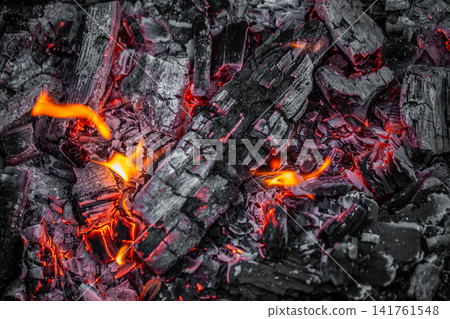 Glowing charcoal embers with flames background close up Glowing charcoal embers with flames background close up 141761548