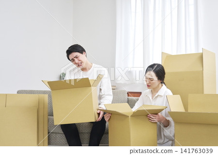 A couple who are exhausted and troubled by the moving process. A couple who are exhausted and troubled by the moving process. 141763039